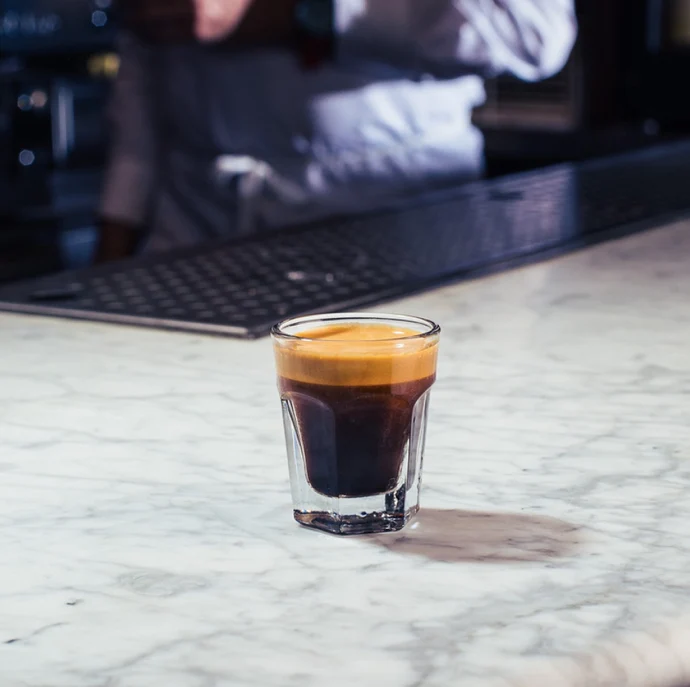 Espresso served in a glass on a marble bar